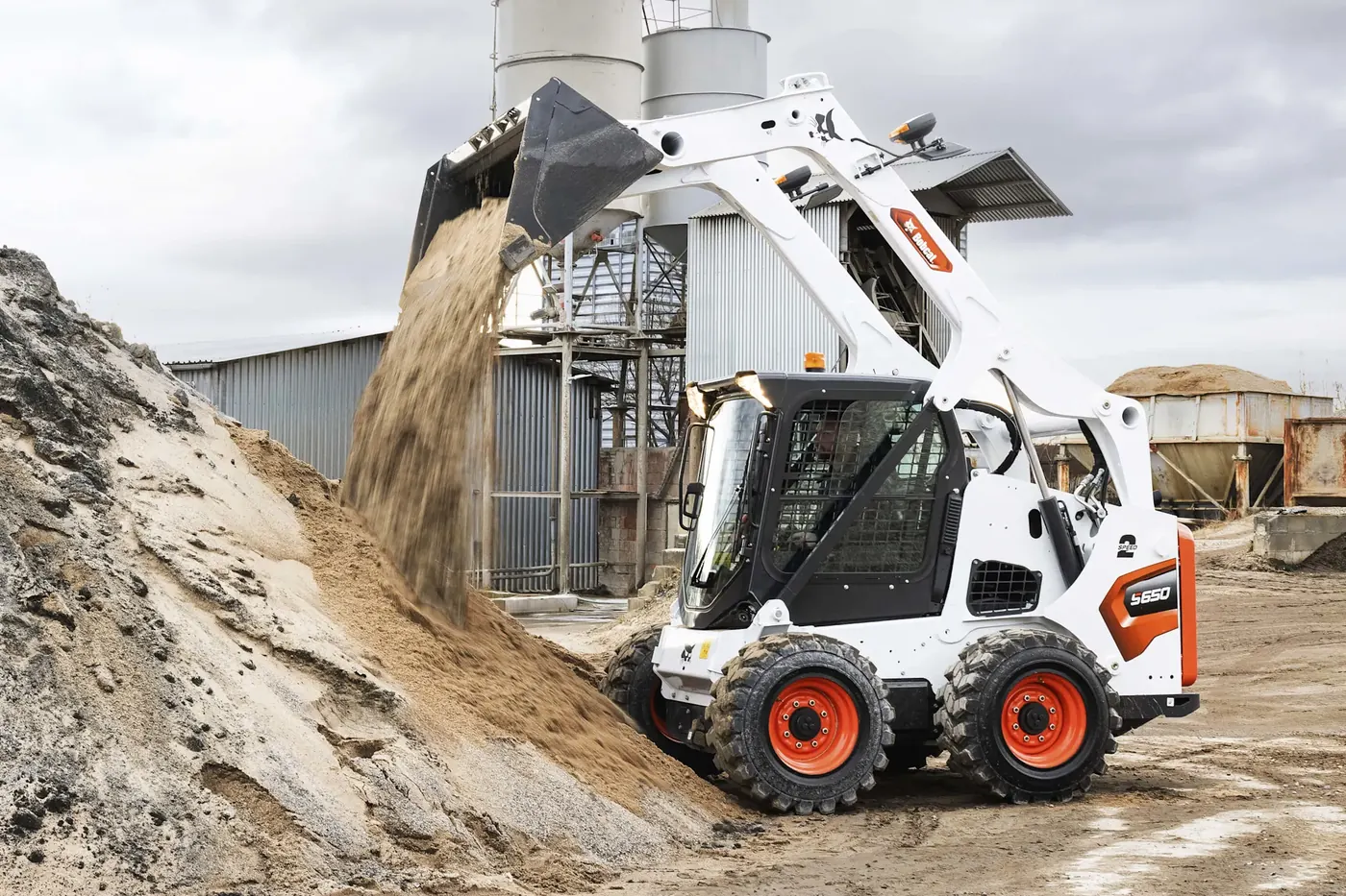 Pala compatta gommata Bobcat S650 che scarica sabbia
